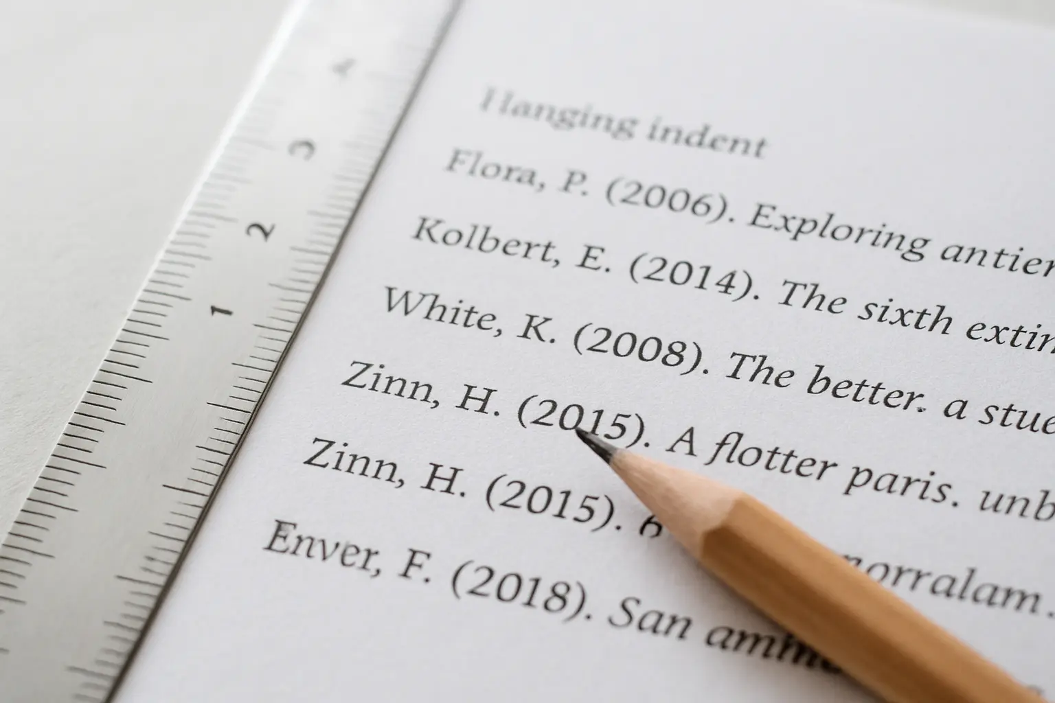 Een geprinte literatuurlijst met hangende inspringing per bron en een liniaal ernaast